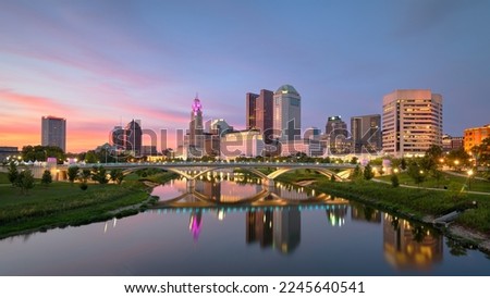 Columbus, Ohio, USA downtown city skyline on the Scioto River after sunset.