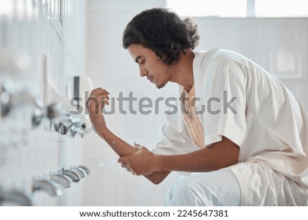 Islam, ablution and man washing before prayer in bathroom at mosque in Iran, spiritual cleaning ritual. Islamic culture, water and worship, muslim guy in cleansing care routine to prepare for praying Royalty-Free Stock Photo #2245647381