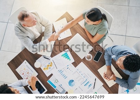 Business people, handshake and meeting with finance report documents for a b2b proposal with an accounting team. Men and women at table for planning with applause and shaking hands for profit growth Royalty-Free Stock Photo #2245647699