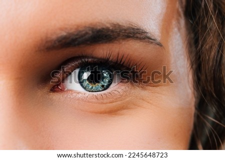 Close up photo of woman blue eye looking at camera