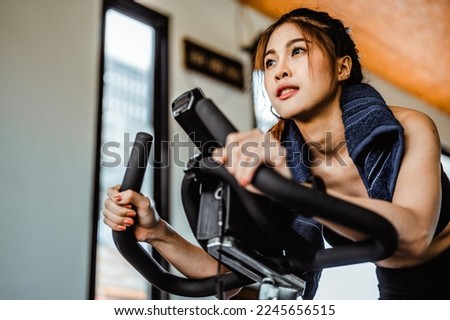 Exercise bike cardio workout at fitness gym.Asian women doing sport biking in the gym for fitness in the morning.Fitness,Gym ,healthy lifestyle concepts. Royalty-Free Stock Photo #2245656515