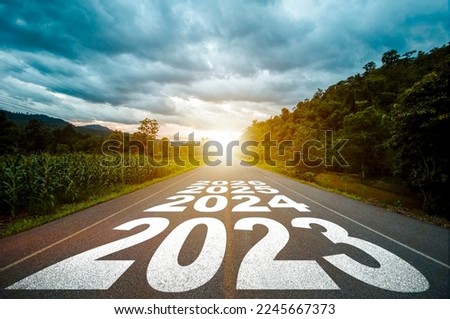 New year 2023 or straight forward concept. Text year 2023, 2024, 2025 written on the road in the middle of asphalt road with at sunset. Concept of planning, goal, challenge, new year resolution. Royalty-Free Stock Photo #2245667373