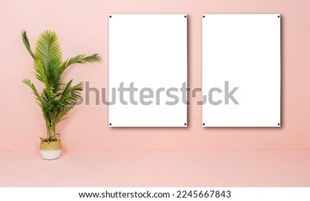 Two blank vertical black poster frame standing on light wooden floor with next to white wall. Blank poster frame mockup, Empty picture. Blank photo frame.