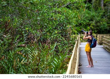 girl photographer looks out for animals while walking in manuel antonio national park near quepos, Costa Rica; wildlife photography in Costa Rican rainforests	
