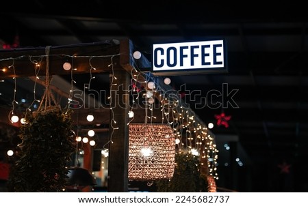 The logo sign of a coffee shop hanged on top of a terrace and coffee roasters market. Concept image for coffee industry.