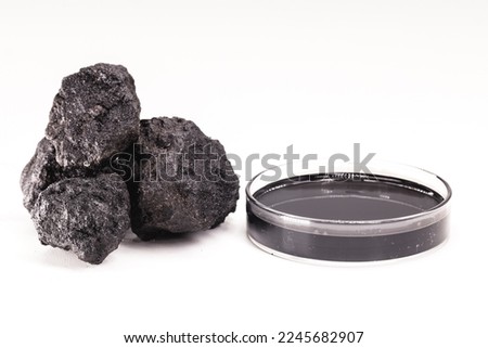petri dish with petroleum, fuel oil, isolated white background, with stone petroleum coke ore, petroleum products and refined products, industrial use Royalty-Free Stock Photo #2245682907