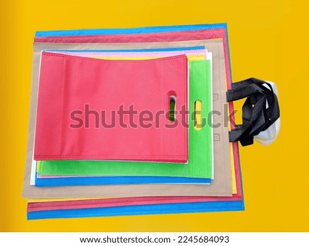 Beautiful Non-Woven Grocery Shopping Bags with a yellow background. Tote ECO-Friendly Bags. Climate change disposable fabric bags
