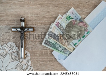 Pastoral visit or Kolęda, Catholic tradition after Christmas in Poland. Cross and envelope with Polish money for priest. Koleda donation for church.