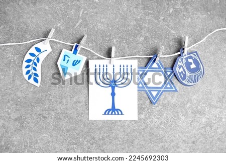 Rope with clothespins and pictures for Hannukah celebration on grunge background