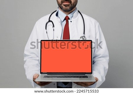 Cropped male doctor IT man wears white medical gown suit work in hospital hold use point on laptop pc computer blank screen workspace area isolated on plain grey background Healthcare medicine concept