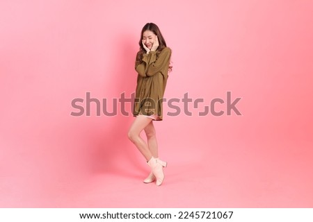 The young adult Asian woman with brown dressed standing on the pink background. Royalty-Free Stock Photo #2245721067