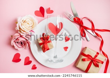 classic festive table setting in valentine's day style with gifts and hearts on a pink background. copy space. top view. 14 february concept Royalty-Free Stock Photo #2245746115