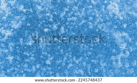 Ice surface with frozen air bubbles, close-up natural texture