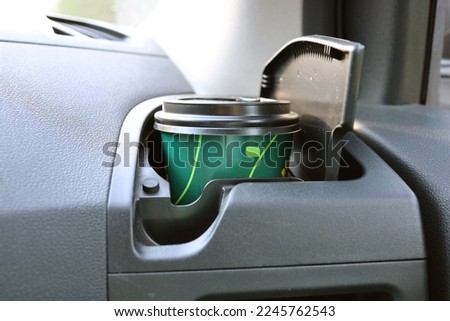 A glass of coffee with you on the road in the cup holder of the car