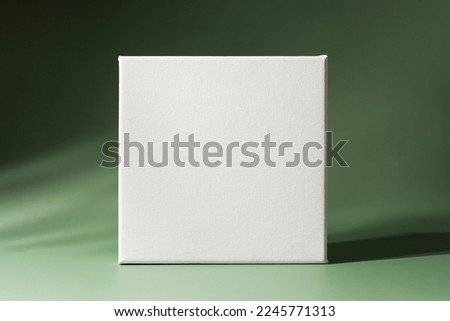 Blank square canvas frame on minimalistic green background. Mockup poster frame.