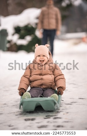 Handsome young dad and his little cute daughter are having fun outdoor in winter. Enjoying spending time together. Family concept. High quality photo