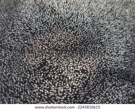 Wavy black shiny fabric with machine knit and lurex (macro, jersey, texture).

