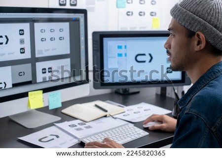 Asian graphic designer working on computer drawing sketches logo design. The concept of a new brand. Professional creative occupation with idea.