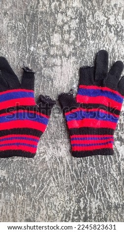 Multicolored knitted gloves made of woolen yarn on a street texture background. the concept of background fashion, style, health, care, medical, wear, protection, safety, security, clothing, clothes