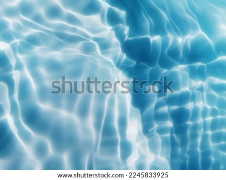 The​ metal​ texture​ of​ surface​ blue​ water​ reflected​ by​ sunlight​ for​ background. Blue​ water​ texture​ in​ the deep​ sea​ for​ background. Reflection​ on​ surface​ blue​ water. Blue​ water​