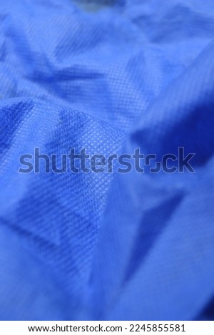background of patterns, shapes and textures of blue shopping bags, shopping bags made of spunbond fabric, selective focus.