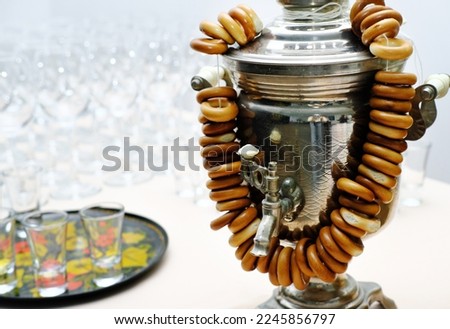 Traditional Russian samovar with a bunch of bagels in white, light room. Horizontal photo