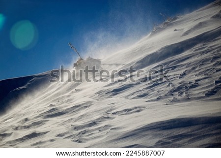 Snow texture. Strong wind in Carpathian mountains in winter on a sunny day. Wind sculpted patterns on snow surface