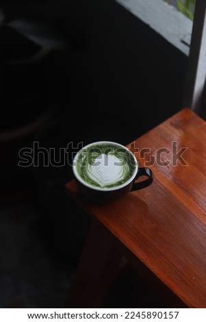 A cup of matcha green tea on the wood table