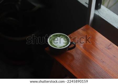 A cup of matcha green tea on the wood table