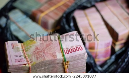 Stack hundreds of 100,000 rupiah banknotes on the table. Indonesian banknotes