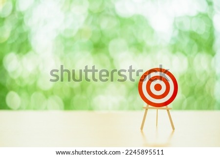 Blank circular target with no darts or a red bullseye on a table. Targets are utilized as a metaphor for corporate success and other means such as target audience, intended business objective.