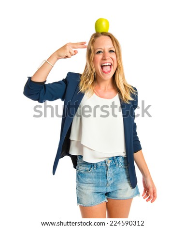 Blonde girl with apple above her head over white background