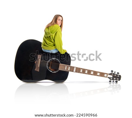 Pretty young girl wearing urban sitting on guitar