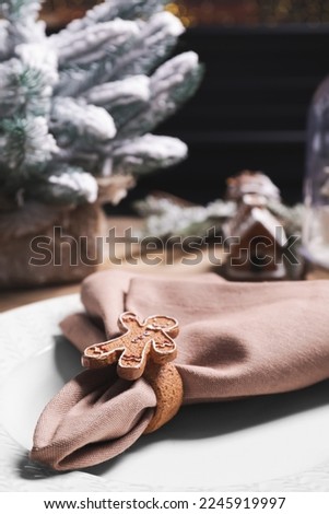 Plate and fabric napkin with decorative ring on wooden table, closeup