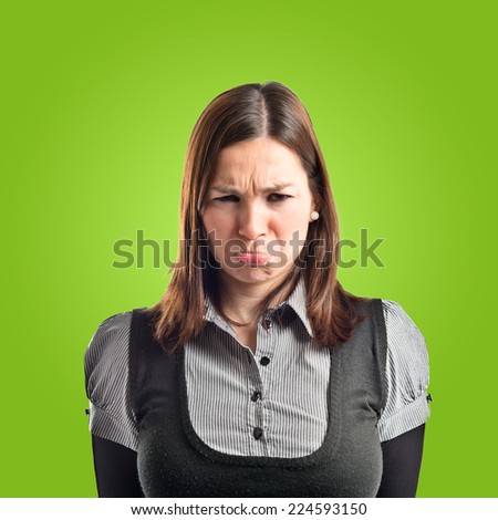Sad young girl isolated over green background 