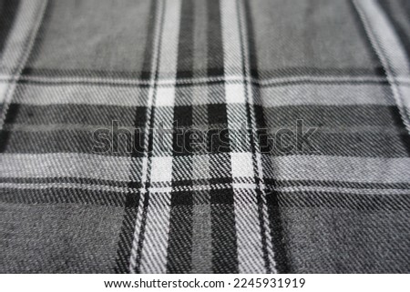 Close view of gray, black and white cotton flannel tartan fabric