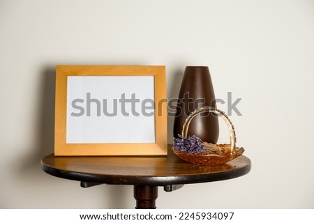 mockup lifestyle interior pedestal table with empty picture frame  vase  and glass basket with dried lavender 