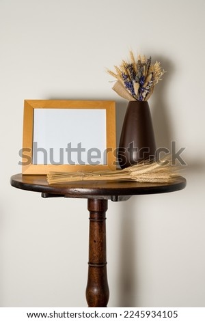mockup lifestyle interior pedestal table with empty picture frame  vase  and glass basket with dried lavender 