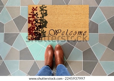 Designer Welcome Entry Doormat Placed on Colorful Tiles Floor with Brown Shoes