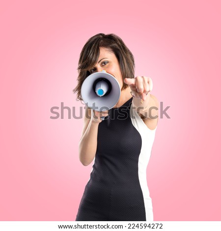 Pretty girl shouting with a megaphone over white background 