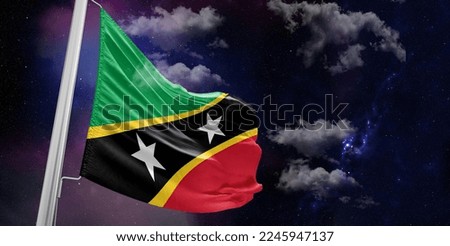 Saint Kitts and Nevis national flag cloth fabric waving on beautiful Blue Background.