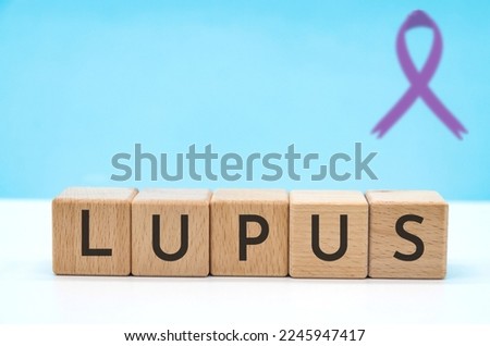 lupus concept with letters on wooden block cubes on blue background with copy space