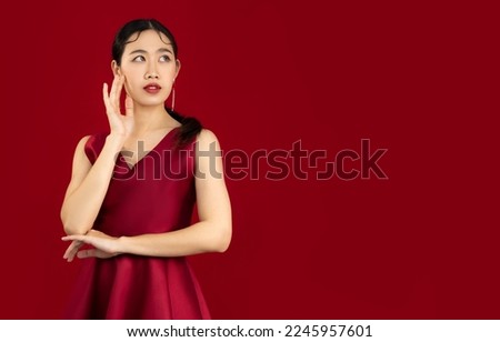 Young beautiful asian woman in elegant red dress posing on red color background, Valentine concept.