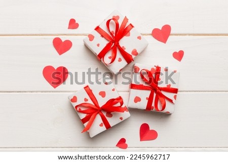 Valentine day composition Background: red gift box with bow and heart. Christmas present. View from above. Holday greeting card.