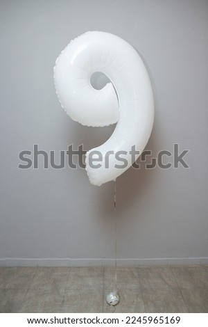 white number 9 foil balloon on wall background