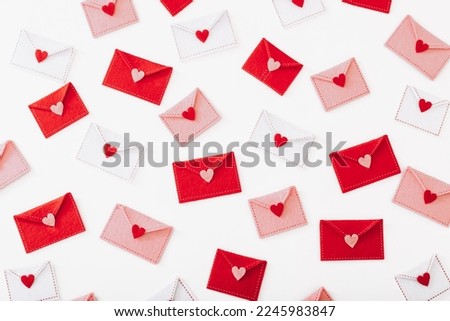Many felt envelopes with hearts on white background, top view