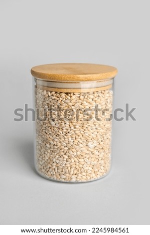 Glass jar of pearled barley on white background Royalty-Free Stock Photo #2245984561