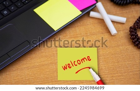 welcome sticky note pasted on the office table at the office
