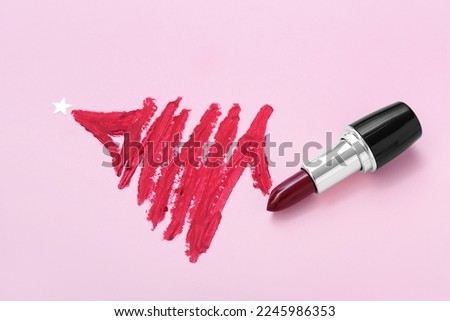 Christmas tree painted with red lipstick on pink background