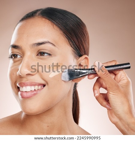 Beauty, makeup and woman with foundation in a studio for cosmetic skincare routine with a brush. Cosmetics, skin and happy girl model from Mexico with a luxury face tone isolated by brown background.